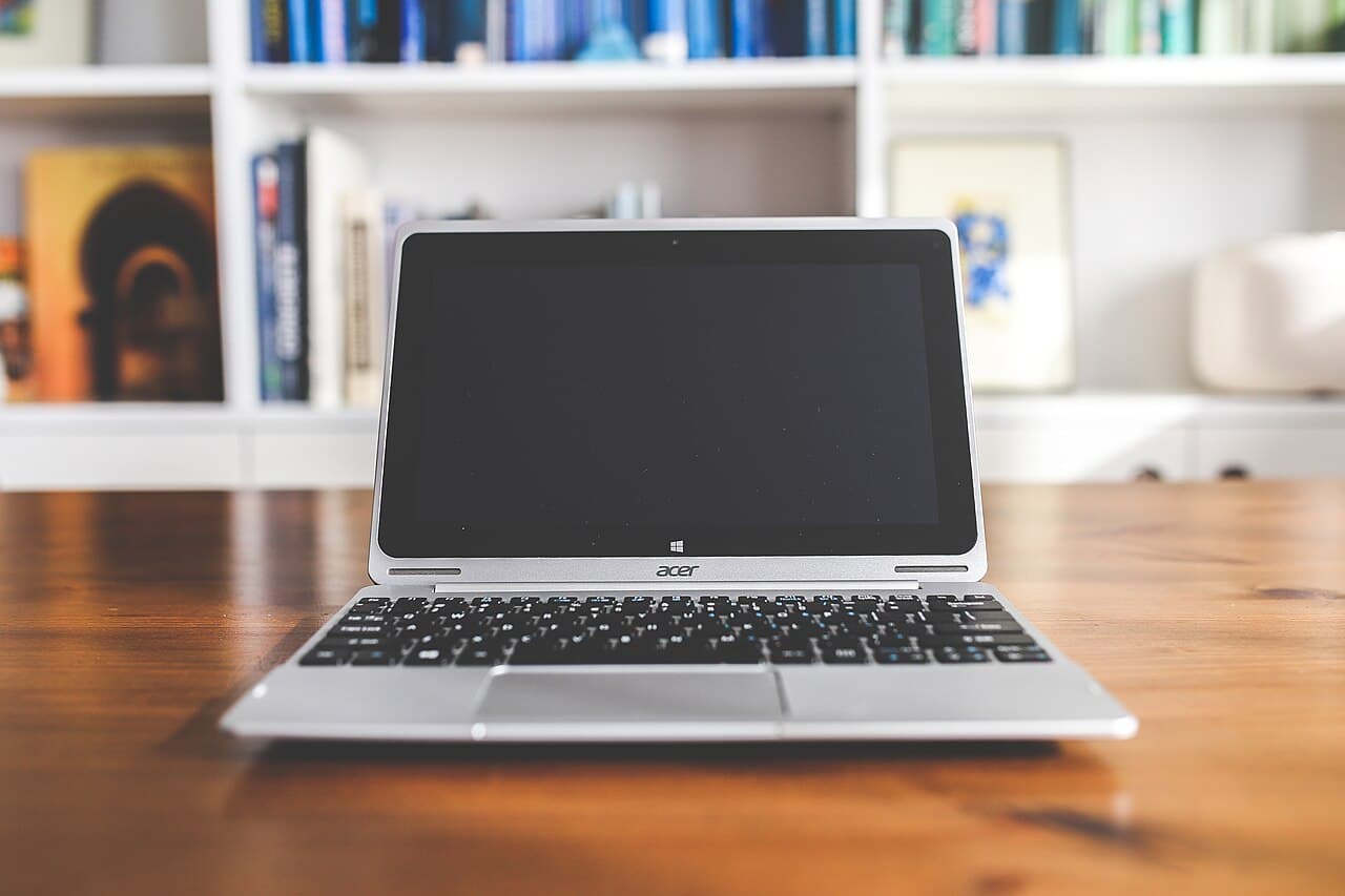 Laptop and paperwork setup used for how to convert PDF to PNG workflows