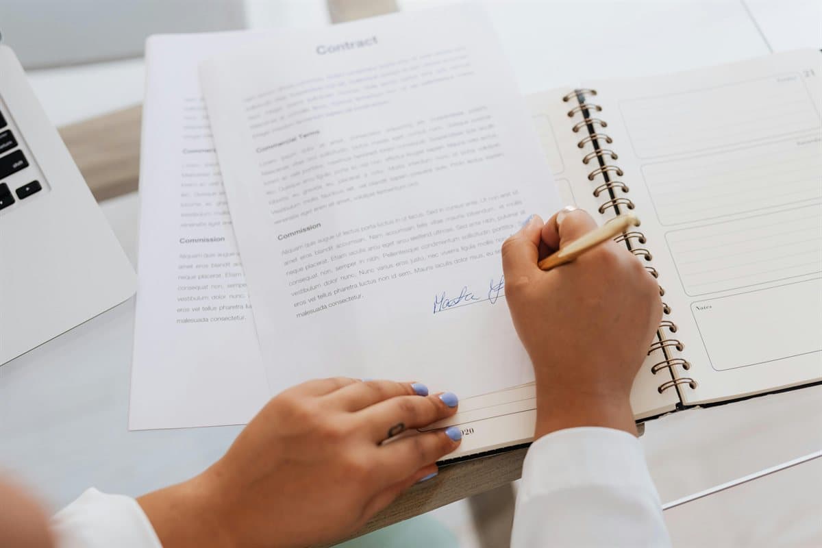 Close-up of contract signing used in a how to watermark a PDF client-delivery workflow