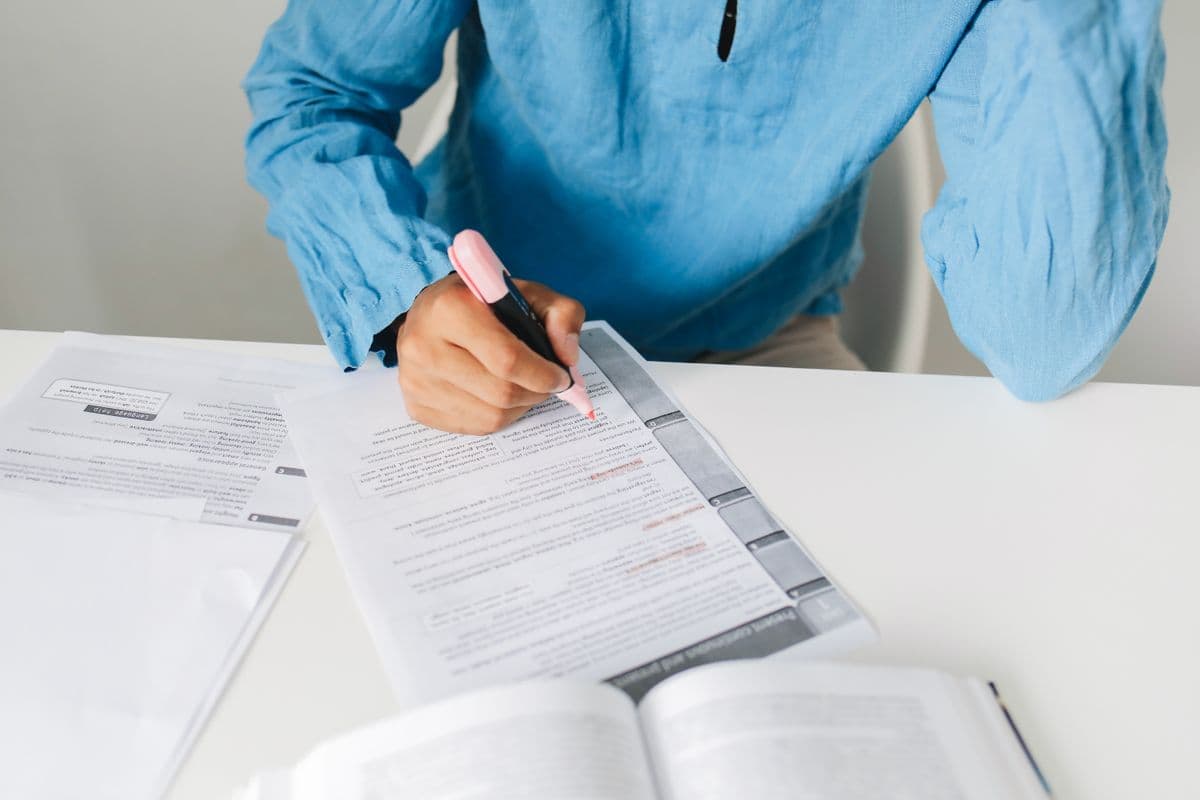Person reviewing a remove highlights from pdf workflow with a marker over document text